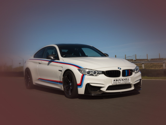 White BMW M4 car racing at Knockhill with a blue sky