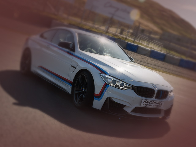 BMW M4 car on the twists and dips of the Knockhill track with sun glare
